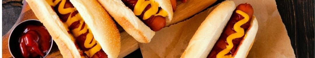 Hot-Dogs auf Holzbrett mit Senf und Ketchup